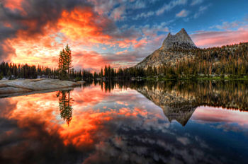 This is a picture of a lake with mountains and a sunset in the background.