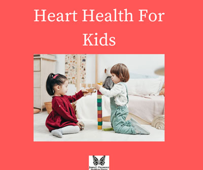 Picture of two toddlers sitting down on the floor and building a tower of blocks. Heart Health For Kids